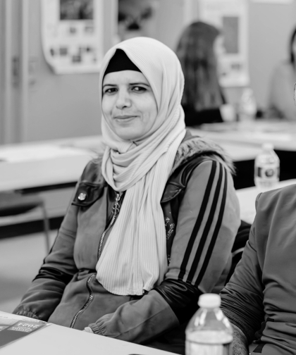 Woman smiling at the camera while attending a session on resources for newcomers to Red Deer.